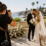 Professional wedding photographer capturing a bride and groom during a luxury beachfront wedding ceremony in San Diego, California.