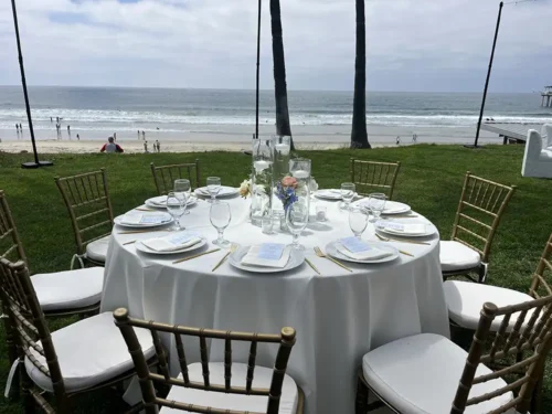 Elegant wedding reception table setup overlooking the beach and ocean in California.