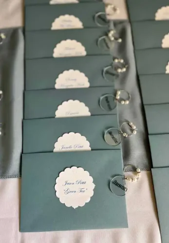 Elegant sage green place cards with scalloped name tags and personalized wine charm favors in Napa Valley.