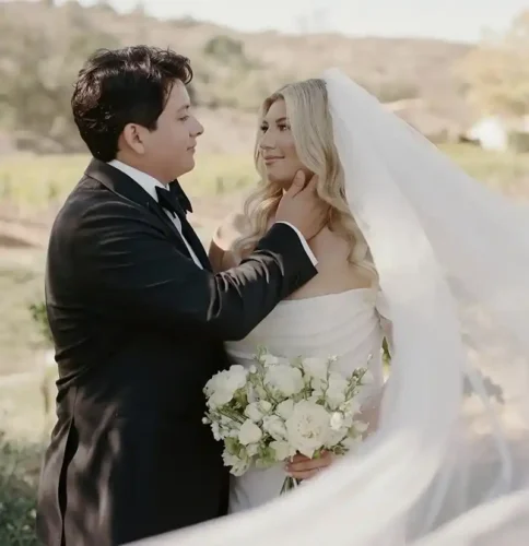 Bride and groom sharing a romantic moment during an elegant outdoor wedding in California.
