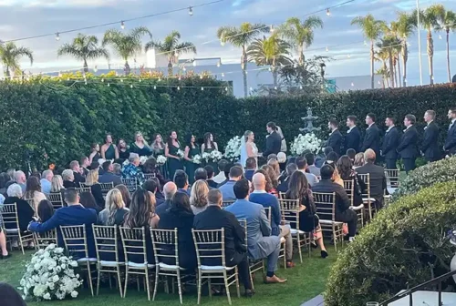 Luxury outdoor garden wedding ceremony with guests and elegant floral décor in Carlsbad, California.