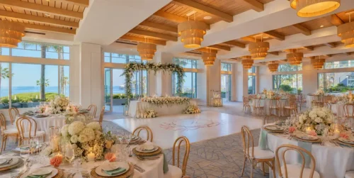 Elegant indoor waterfront wedding reception venue with floral décor and reception tables in California.