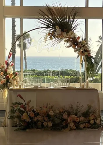 Elegant oceanfront sweetheart table with luxury floral wedding décor designed by Butterfly Soiree in San Diego.