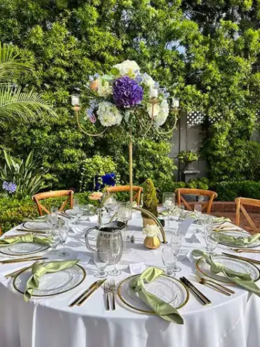 Elegant outdoor wedding reception table with tall floral centerpiece and gold place settings in Paso Robles, California.