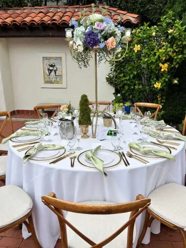 Elegant wedding reception table with floral centerpiece and gold place settings at a luxury venue in Carmel-by-the-Sea, California.