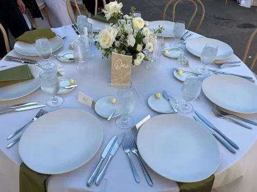 Elegant wedding reception table setting with white dinnerware, floral centerpiece, and modern place settings at a luxury wedding venue in Napa Valley, California.