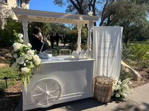 Elegant wedding welcome cart with white floral arrangements at a luxury outdoor wedding venue in Napa Valley, California.