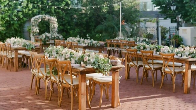 Elegant outdoor wedding reception in Downtown San Diego's Gaslamp District featuring rustic wooden tables, floral centerpieces, and a romantic courtyard setting.