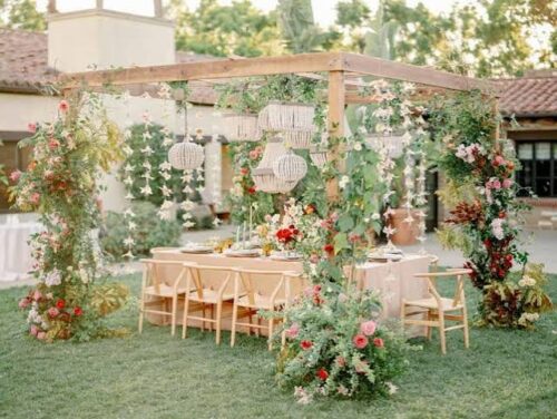 Secret garden estate wedding ceremony with trees, flowers, and romantic outdoor setting
